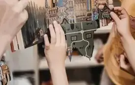 Przedszkolaki oglądają tr&oacute;jwymiarowy obrazek w książce prezentowanej przez bibliotekarkę.