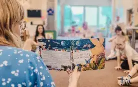 Bibliotekarka czyta dzieciom książkę.