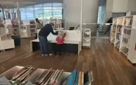 Wnętrze biblioteki - a w nim umieszczone regały z książkami.