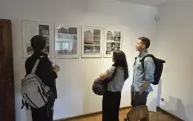 Trzy osoby w gabinecie Christy Wolf oglądają ekspozycję zawieszona na ścianie