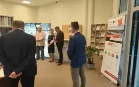 Zdjęcie przedstawia tę samą sytuację, co poprzednie, jednak z większej odległości. Przez to na pierwszym planie w centrum widać kierownika Działu Zbior&oacute;w Regionalnych oraz jednego z uczestnik&oacute;w spotkania po lewej
