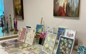 Obraz z baletnicą, na przeszklonej gablocie obrazki w delikatnych kolorach.
