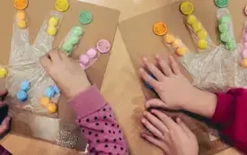 Przedszkolaki segregują pomponiki według kolor&oacute;w.