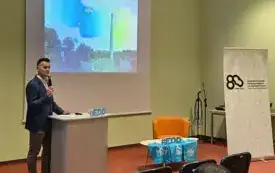 Zdjęcie przedstawia tę samą sytuację, tylko wykonano je w zbliżeniu na prelegenta i lekko z prawego profilu.