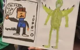 Uczeń trzyma w ręce dwie ilustracje do legendy - na jednej z nich zielony smok, na drugiej tiktoker promujący legendę