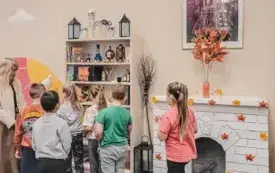Dzieci oglądają książki z serii o Harrym Potterze na bibliotecznym regale. 