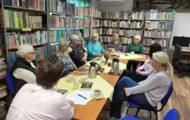 Widok od szczytu stołu na zebranych członk&oacute;w Klubu