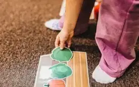 Uczestnicy zajęć segregują warzywa i układają je w skrzynkach.