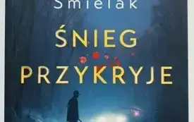 Okładka książki Michała Śmielaka &bdquo;Śnieg przykryje" przedstawia mroczną, zimową scenerię i stojącego na ośnieżonej drodze mężczyznę z toporem w dłoni, w tle widać reflektory samochodu oraz ślady krwi na śniegu. W prawym dolnym rogu okładki umieszczono czer