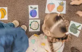 Przedszkolaki układają ilustracje przedstawiające owoce i warzywa.