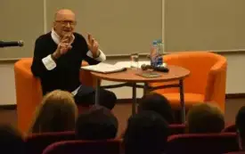 Wojciech Pszoniak unoszący dłonie w g&oacute;rę. 