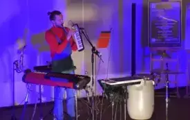 Artysta gra na instrumentach klawiszowych.