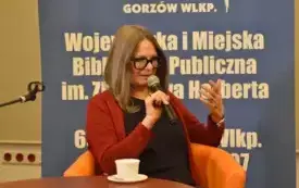 Osoba wyrażająca emocje. W ręku trzyma mikrofon.