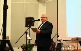 Dyrektor Biblioteki Herberta stoi przed mikrofonem i czyta