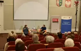 Spotkanie autorskie z Tomaszem Jachimkiem. Publiczność słucha rozmowy dw&oacute;ch os&oacute;b na temat książki