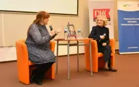 Spotkanie autorskie z Marią Pakulnis. Publiczność słucha rozmowy dw&oacute;ch os&oacute;b na temat książki.