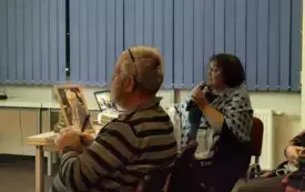 Grażyna Kostkiewicz-G&oacute;rska opowiada o Zbigniewie Czarnuchu. Na stoliku przed nią portret zmarłego Czarnucha z czarną wstążką