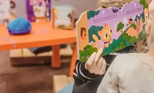 Pani Bibliotekarka czyta dzieciom książkę. 