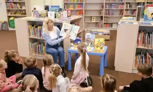 Bibliotekarka czyta dzieciom książkę.