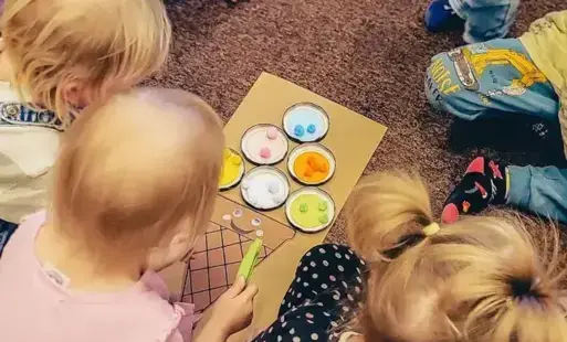 Dzieci układają pompony według koloru. 
