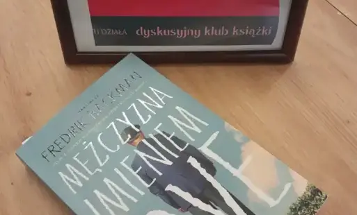 prezentacja książki na tle tabliczki DKK