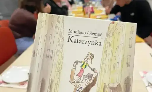 Okładka książki pt. 'Katarzynka'. W tle osoby siedzące przy stole.