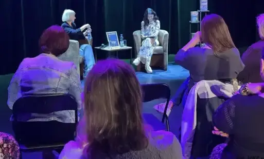Dwie kobiety siedzą na estradzie.