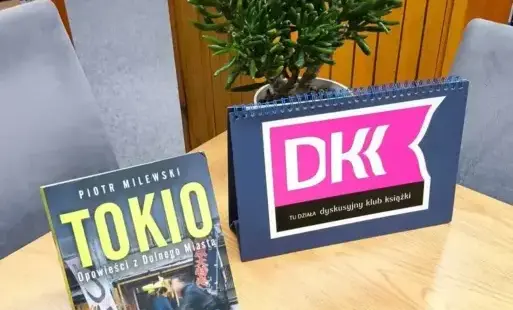 Okładka książki na stole w tle roślina w doniczce