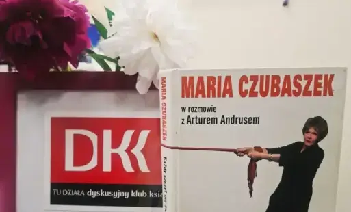 Po prawej stronie książka autorstwa Marii Czubaszek w rozmowie z Arturem Andrusem, zatytułowana ,, Każdy szczyt ma swój Czubaszek''Po lewej stronie -Różowa ramka z logo Dyskusyjnego Klubu Książki