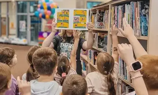 Bibliotekarka pokazuje dzieciom komiks o Pippi.