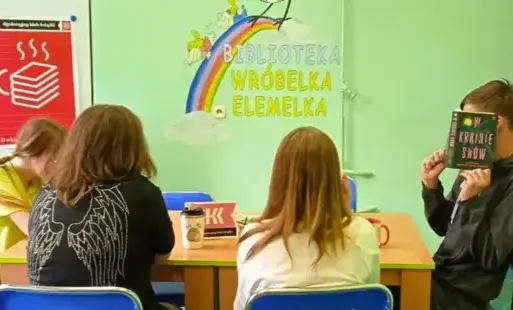 cztery osoby przy stole dyskutują na temat książki