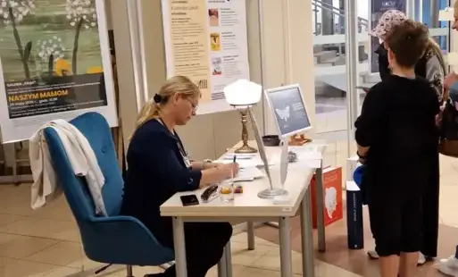 Punkt czytelniczy z „Książką na receptę”. Biblioterapeutka wypisuje 'receptę' na lekturę.