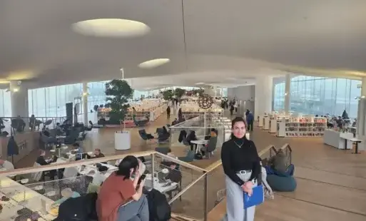 Osoba stoi w wewnątrz gmachu biblioteki.