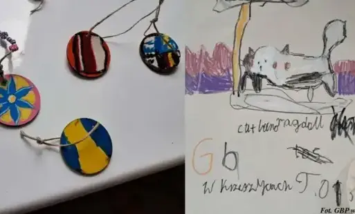 Malowane drewniane zawieszki oraz dziecięcy rysunek kota z podpisem.