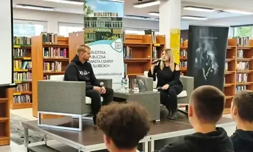 Dwoje prelegentów rozmawia na scenie przed zgromadzoną publicznością.