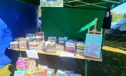 Plenerowe stoisko Biblioteki, zorganizowane pod zielonym namiotem.