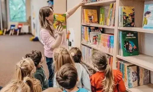 Tytułowe – Bibliotekarka oprowadza dzieci po Oddziale Dziecięcym.