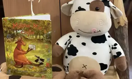 przedstawia książkę J Wieslander „Mama Mu czyta” oraz maskotkę – krowę.