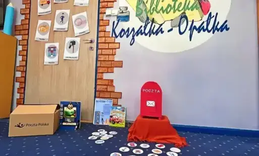 Tytułowe - Na tle ściany kartonowa skrzynka na listy, książeczki i karton.