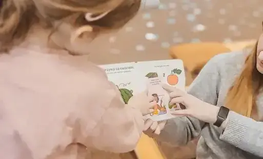 Tytułowe. Dziecko otwiera okienko w książce.