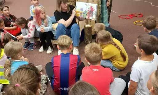 Bibliotekarka czyta książkę uczniom ze Szkoły Podstawowej w Ulimiu