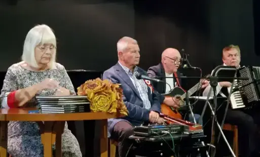 Zdjęcie główne: Obsada spotkania biorąca udział w promocji tomiku „Niebo pękało sierpniem”, od lewej: Krystyna Woźniak (autorka), Czesław Ganda (prezes RSTK), Jacek Kostyszak (gitara), : Stanisław Dobrzański (akordeon).