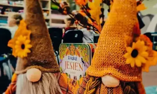 Tytułowe: Na stole stoją dwa krasnale ubrane w jesienne stroje.