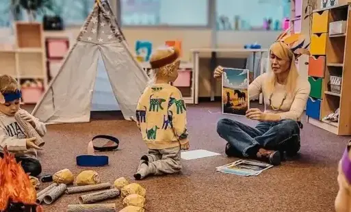 Tytułowe: Bibliotekarka czyta dzieciom opowieść o Indianach.