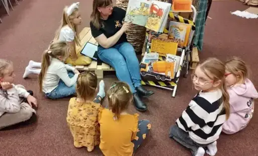 Bibliotekarka czyta dzieciom książkę.