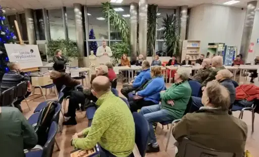 Wydawcy i czytelnicy zgromadzeni w holu słuchają Michała Gierkego prezentującego książki Książnicy Pomorskiej