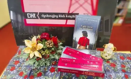 W kompozycji tytułowej  omawiane książki leżą na stole. Za nimi stoi plansza logo DKK. Po lewej stronie jest bukiet świąteczny.