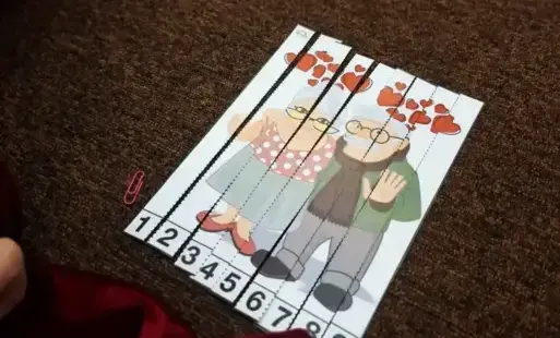 Dziecko układa puzzle przedstawiające babcię i dziadka.