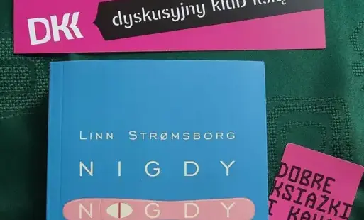 Na zielonym obrusie książka „Nigdy, nigdy, nigdy” autorstwa Linn Strømsborg.