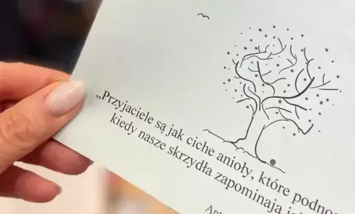 Kartka z cytatem „Przyjaciele są jak ciche anioły, które podnoszą, kiedy nasze skrzydła zapominają jak latać” Antoine de Saint-Exupery.